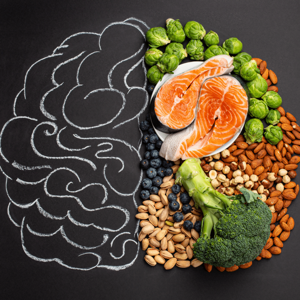 A chalkboard flatlay with a drawing of a brain on one side and a series of healthy foods on the other